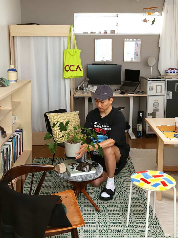 ナチュラルトーンのコンパクトなホームオフィス、中央に植物と多彩なスツールが配置されたモダンな空間
