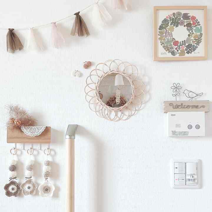 Natural tone entrance interior featuring wood tone framed mirror and decorative wreath creating a cozy atmosphere