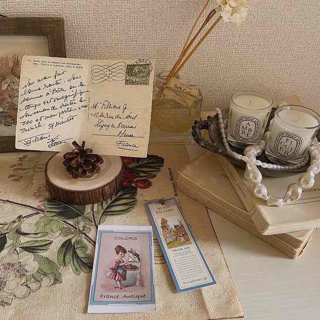 A natural-toned entrance table featuring vintage picture frame, candles, and diffuser arranged in a cozy setting