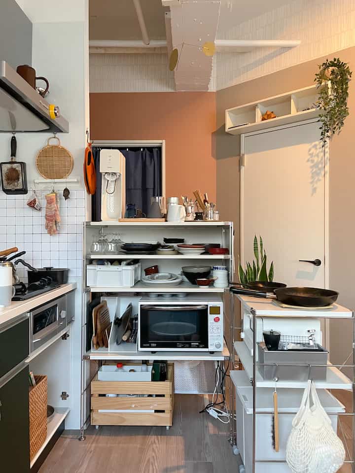 ナチュラルカラーとホワイトが調和したキッチン、メタルシェルフに収納アイデアが映える印象的な空間