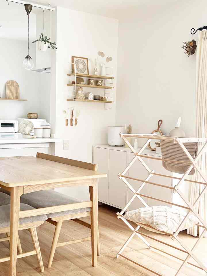 ナチュラルな木目調と白を基調としたダイニング、効率的な収納キャビネットと棚が配置された清潔感のある雰囲気の空間