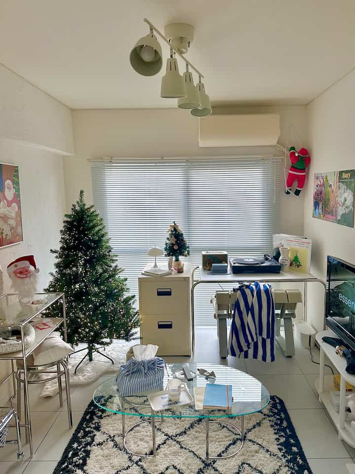 White walls and modern furniture in a living room featuring Christmas trees and string lights in a neat setting