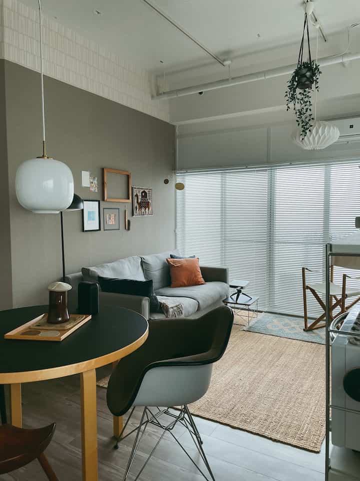 グレーのソファとベージュのラグが配置された、ナチュラルモダンな雰囲気のリビングとダイニングの空間