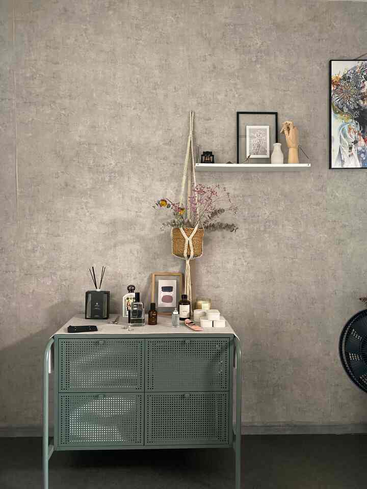 グレーのテクスチャウォールとグリーンのメタルチェストが配置されたナチュラルモダンなインテリア