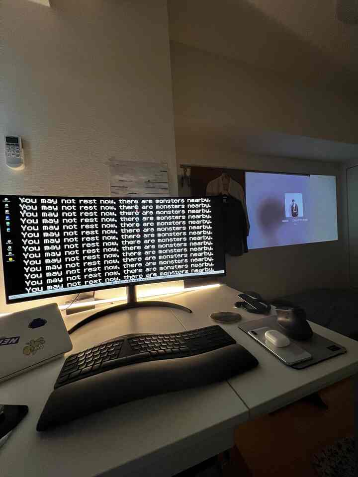 白を基調としたワークスペース、コンパクトな部屋にモニターとキーボードが配置されたインテリア