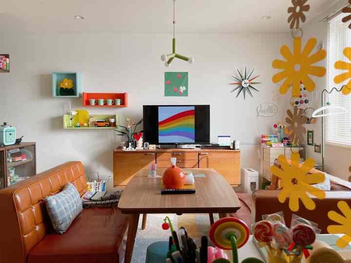 明るいライトブラウンの色調のリビング、キャラメル色のソファと木製のダイニングテーブルが配置されたレトロなミッドセンチュリーモダンの空間