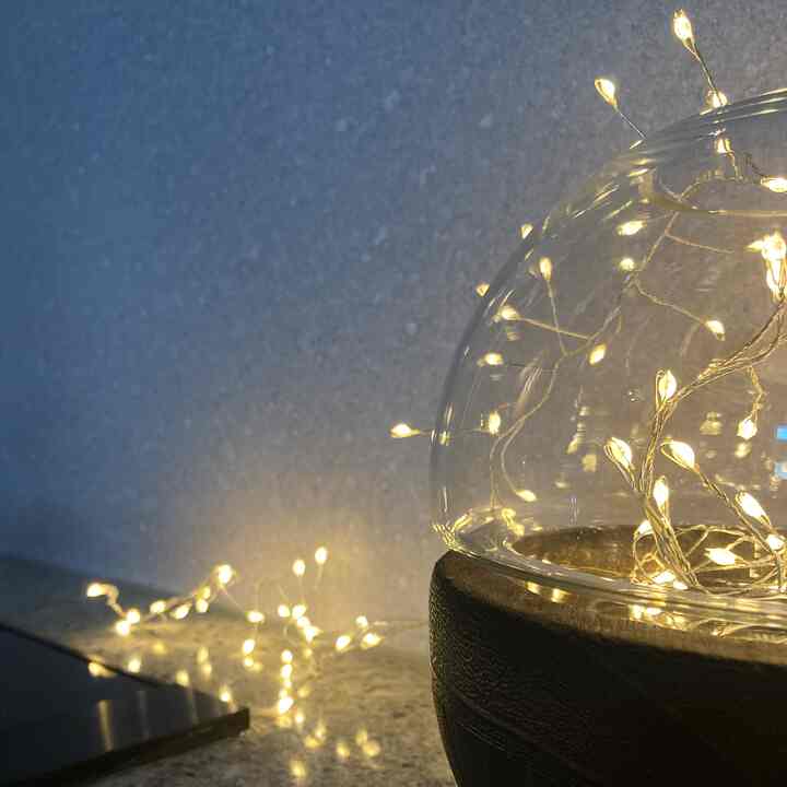 Transparent glass dome with warm gold-toned LED string lights creating a cozy ambiance
