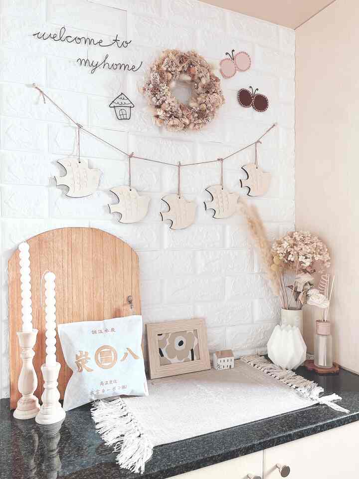 Bright white brick wall entrance featuring natural color decorations and organized cabinet surface creating cozy warmth