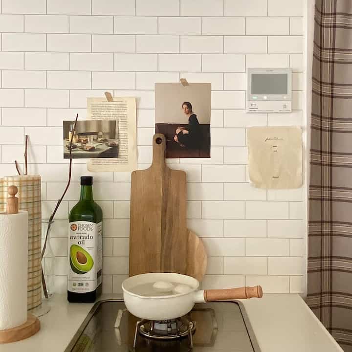 白いレンガのタイルと木目調の調理器具が配置されたシンプルなキッチンのインテリア