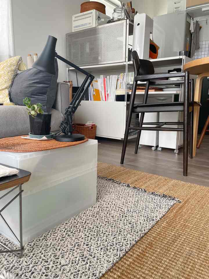 ナチュラルな色調のリビングとキッチンがつながる空間、ソファ前の仮置きサイドテーブルとラグが調和した雰囲気のあるインテリア