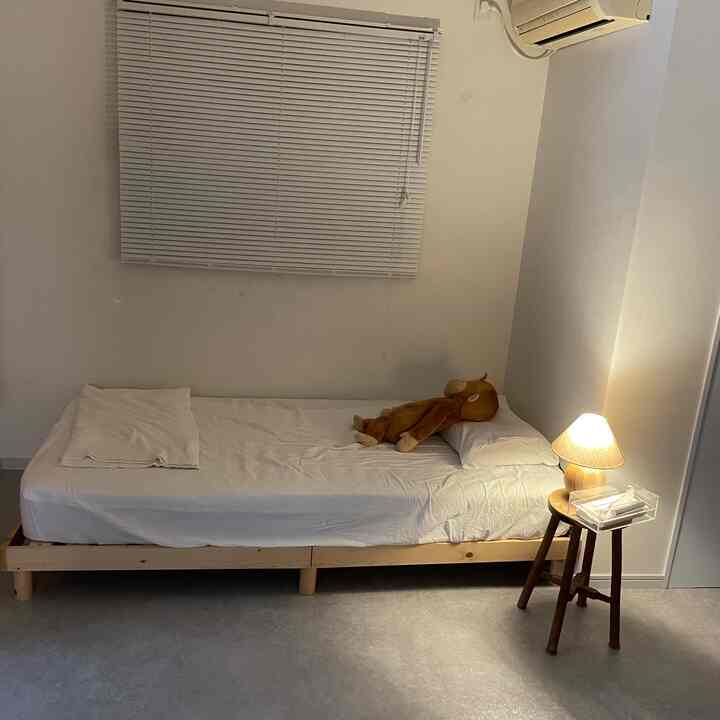 Natural tone bedroom featuring wooden bed and blinds in a simple, cozy atmosphere