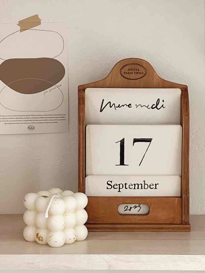 Natural wood and white-toned entrance featuring a wooden calendar and white bubble candle arranged cozily