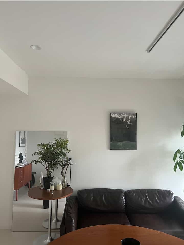 ナチュラルカラーの壁とブラウン家具が配置されたモダンなリビングスペース