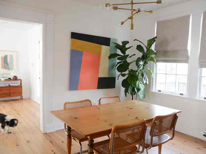 Bright white-walled dining room with natural wood dining table and chairs, featuring a fresh natural atmosphere