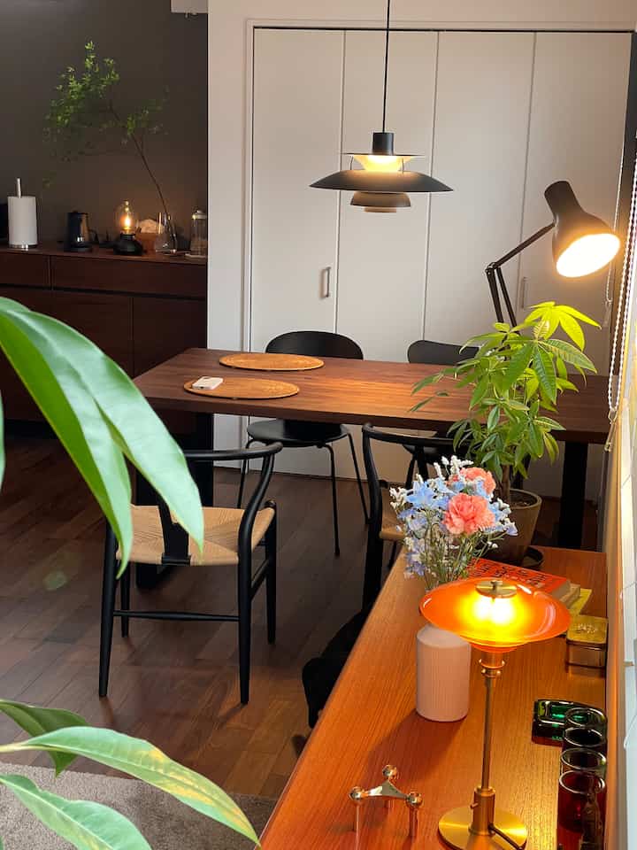 ナチュラルなブラウンの木目調ダイニング、黒のCH24 Yチェアとペンダントライトが配置された温かみのある空間