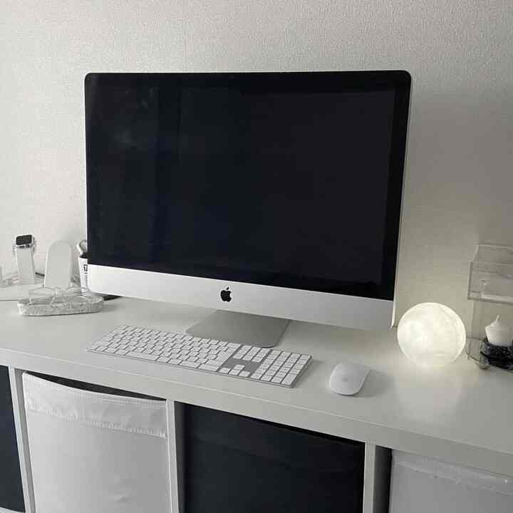 モノトーンのホワイトトーンのワークスペース、iMacとApple製周辺機器、LEDムーンタッチライトが配置されたシンプルな作業空間