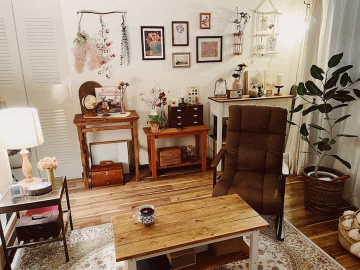 Cozy living room with warm brown and natural wood tones, featuring wooden furniture and plants