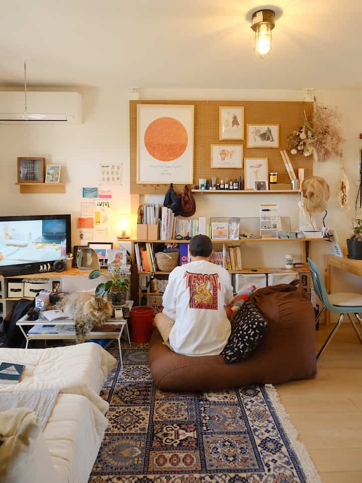 Warm brown and white toned living room featuring a bean bag sofa and bookshelf with a cozy natural atmosphere