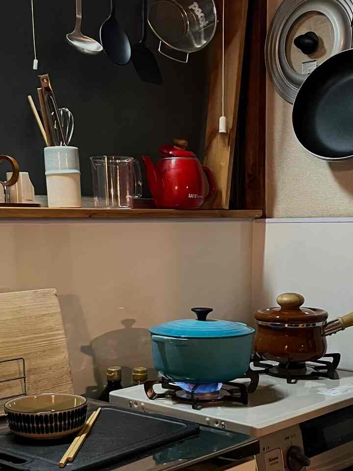 Natural wood tones with blue accents in a kitchen featuring cooking utensils and pots on a stove with a cozy atmosphere