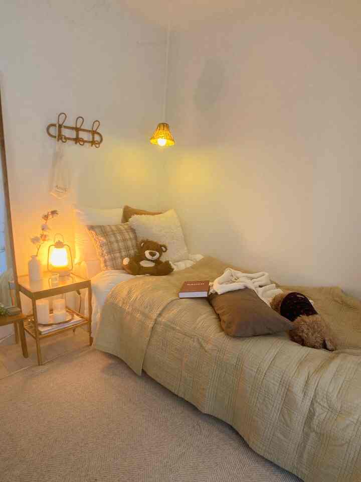 ベージュを基調としたナチュラルな寝室、快適なベッドとラタンのペンダントライトが温かみのある雰囲気を演出する空間