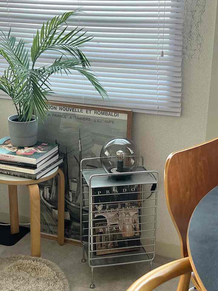 ホワイトブラインドと木目調家具、植物が配置された自然な雰囲気のリビングの一角