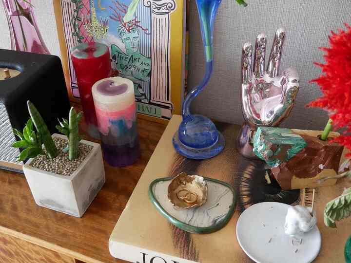 木目調のサイドボードに装飾用キャンドル、植物、アートフレームが配置されたヴィンテージスタイルのインテリア