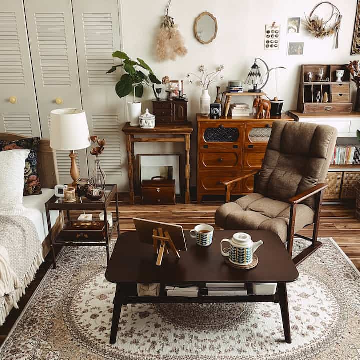 ナチュラルな色調のリビング、ブラウンのコーヒーテーブルとアームチェア、ペルシャ柄のラグが調和した印象的な空間