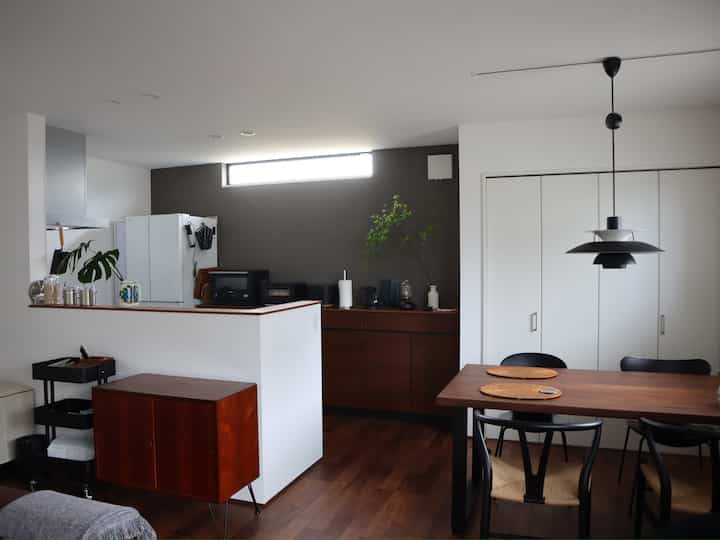White and wood tone kitchen and dining room with simple, natural style creating a calm atmosphere