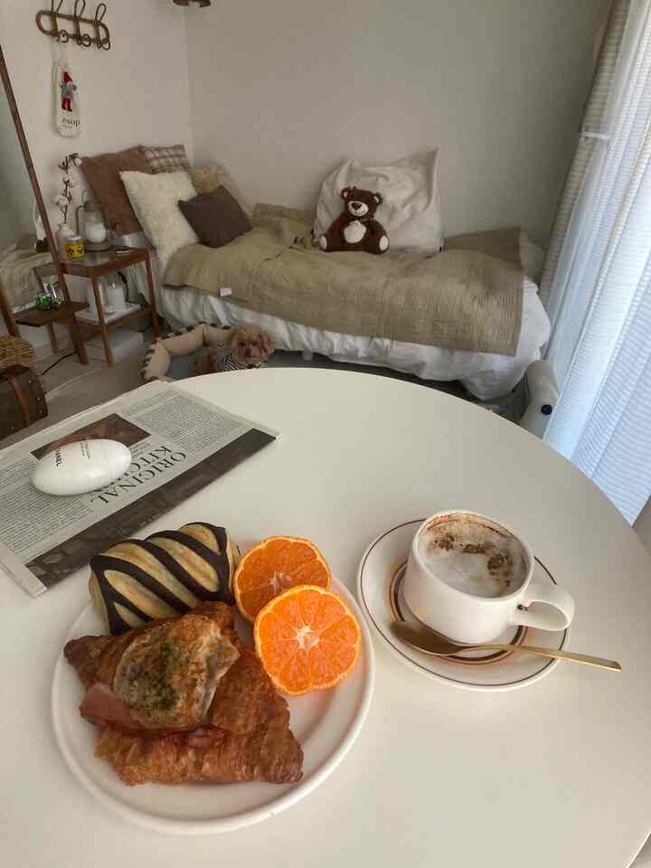 A beige and brown toned small living space near a veranda, featuring cushions, a dog bed, and natural elements suited for a single household