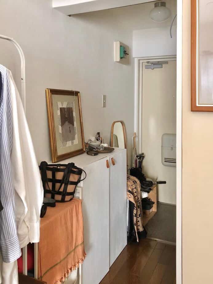 ホワイトの壁とナチュラルウッドの床が特徴の狭い玄関廊下、IVARのキャビネットとシューズラックが配置された温かみのある空間