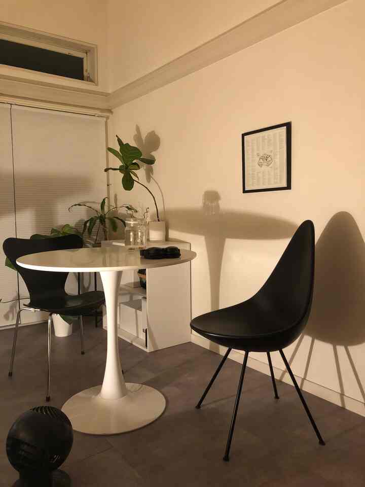 A Nordic-style compact dining space for single household featuring white and black tones with cafe-style furniture