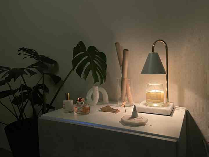 ホワイトトーンの小さな玄関空間、植物とキャンドル、テーブルランプが配置された落ち着いた雰囲気のインテリア