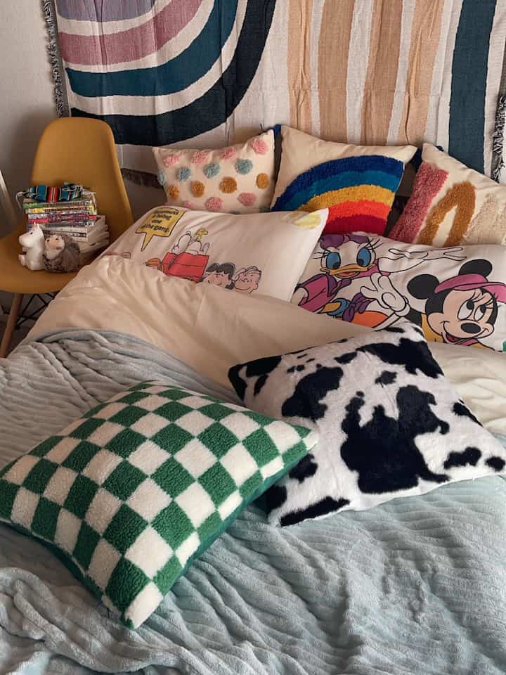 Colorful cushions and wall decor in a natural blue-toned bedroom