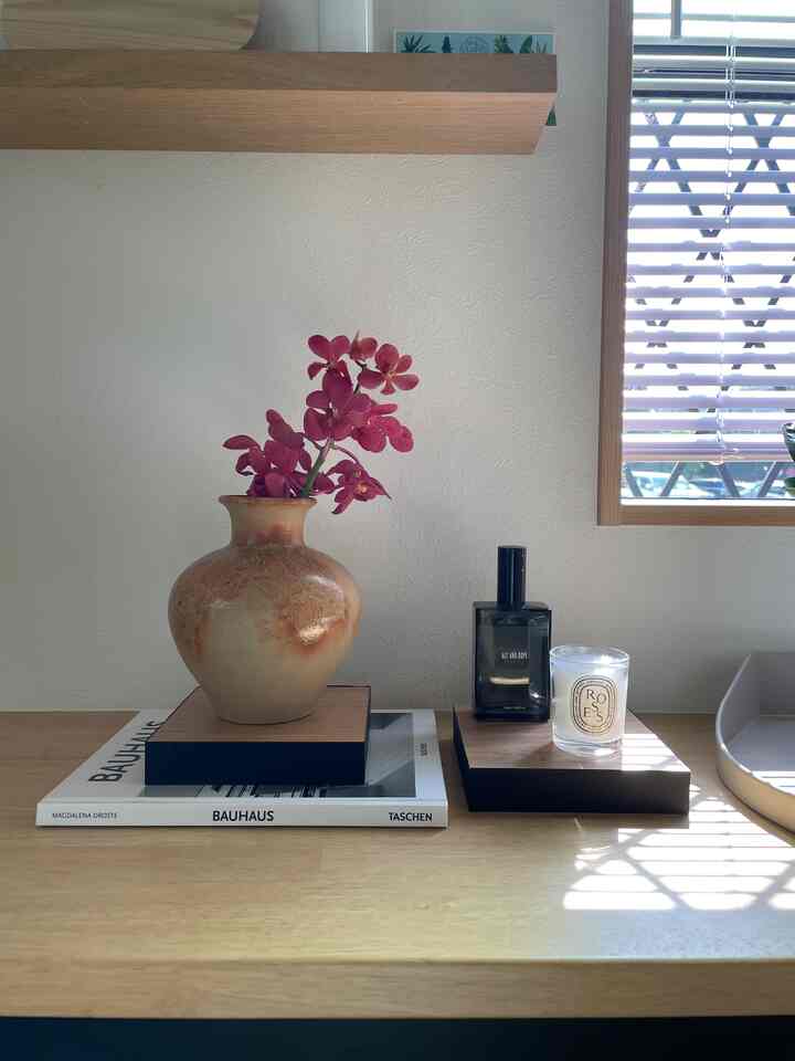 木目調とナチュラルスタイルのダイニング、花瓶やディフューザー、キャンドルが配置された雰囲気あるインテリア