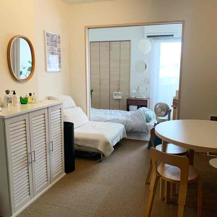 White and brown toned studio apartment living room with wooden furniture and a simple, natural layout