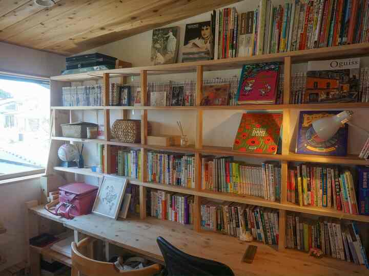 ナチュラルな色調の子供部屋、広い本棚と机、ピンクのランドセルとオフィスチェアが配置された雰囲気のある学習スペース