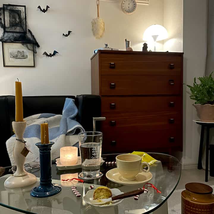 温かみのあるブラウン家具と黒いソファが配されたナチュラルで落ち着いたリビング、ホームカフェを感じさせるコーヒーテーブルと照明