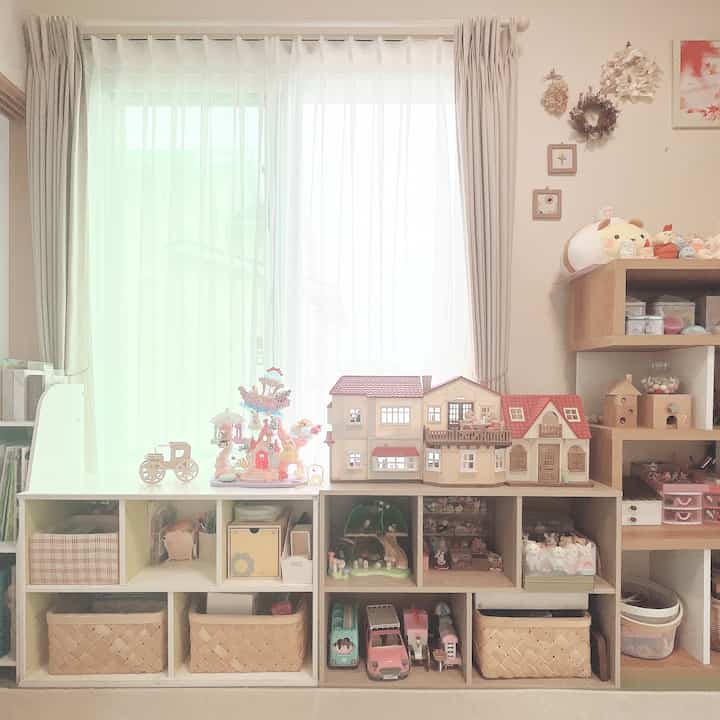白とナチュラルウッドの調和が取れた子供部屋、整頓された収納とおもちゃが配置された温かみのあるインテリア