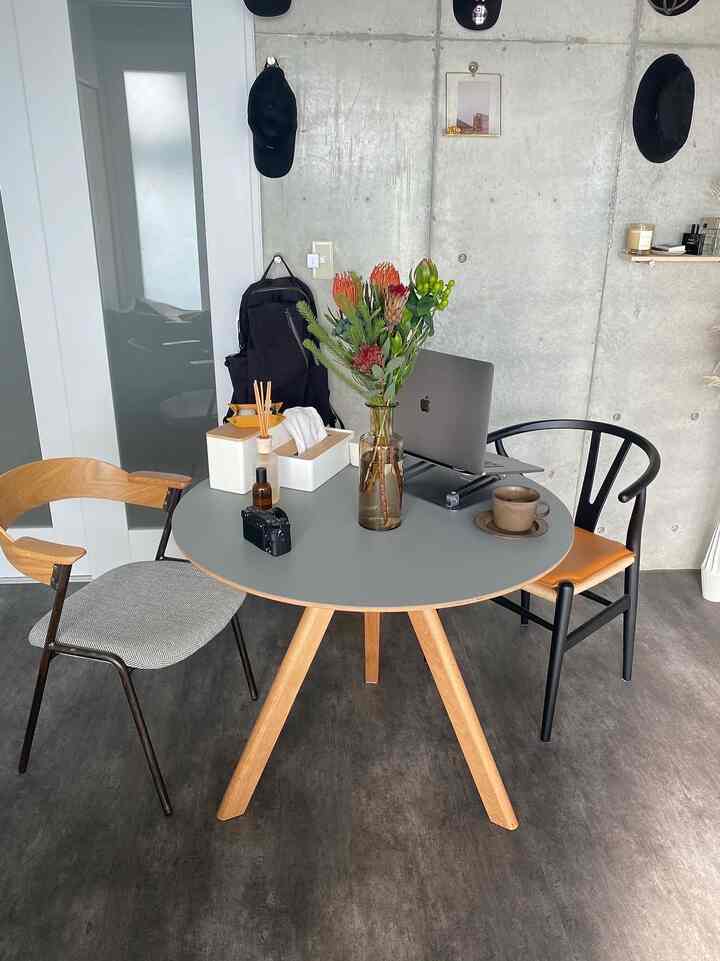 グレー調のダイニングルーム、木製テーブルと黒と木目調の椅子が配されたモダンなインテリア