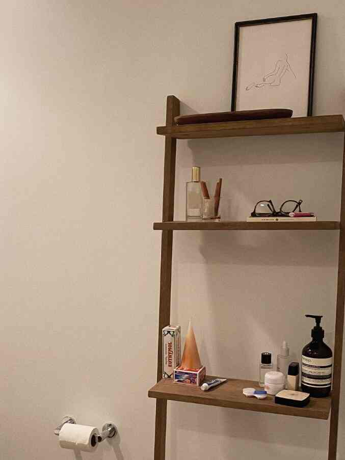 Natural-toned bathroom shelves with hygiene products arranged in a minimalistic and warm atmosphere