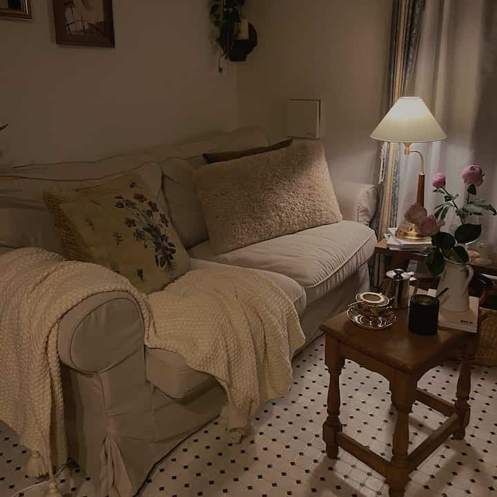 温かみのあるナチュラルカラーのリビング、ベージュのソファと木製のコーヒーテーブルが配置された雰囲気のある空間