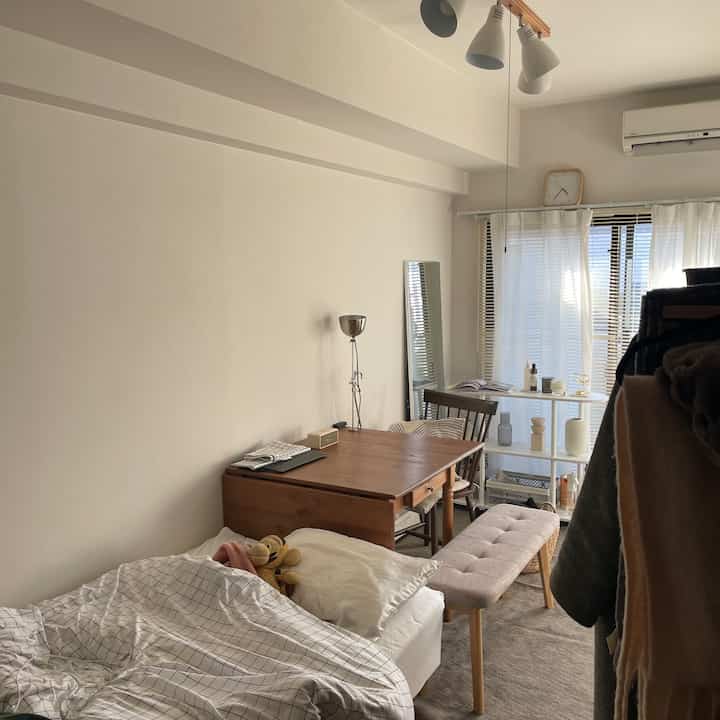 白と茶色のトーンでまとめられた二人暮らし用ダイニング、ナチュラルな木製家具とベンチが配置された雰囲気のあるインテリア