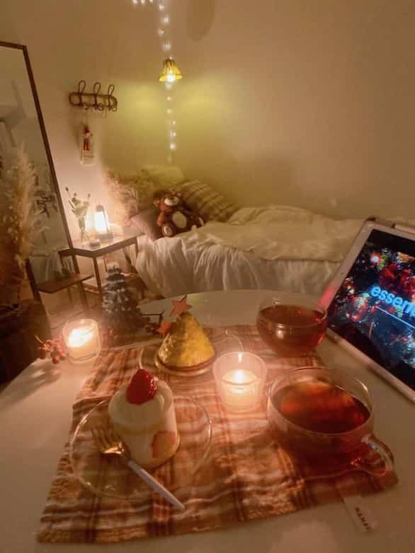 Cozy bedroom in warm white and brown tones featuring Christmas candles and home cafe desserts on a table