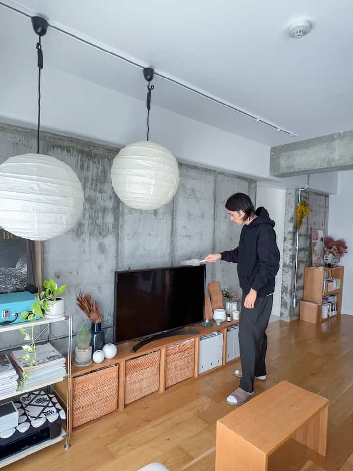 Natural wood tone and simple Muji-style living room featuring pendant lights and TV stand in a clean, minimalist space