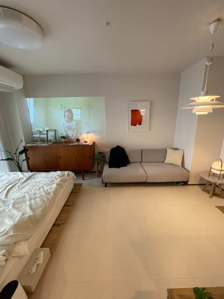 Natural-toned 1K living room featuring bed, sofa, and sideboard with clean natural modern interior