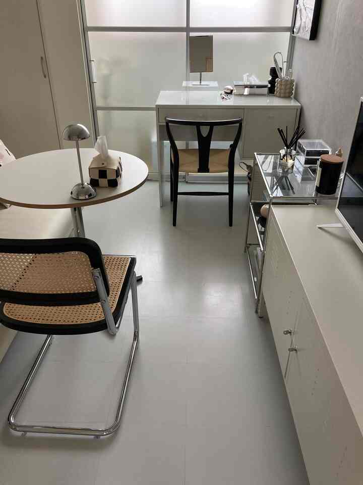 Narrow single household room in white and natural brown tones, featuring minimal furniture and home cafe elements with a clean atmosphere