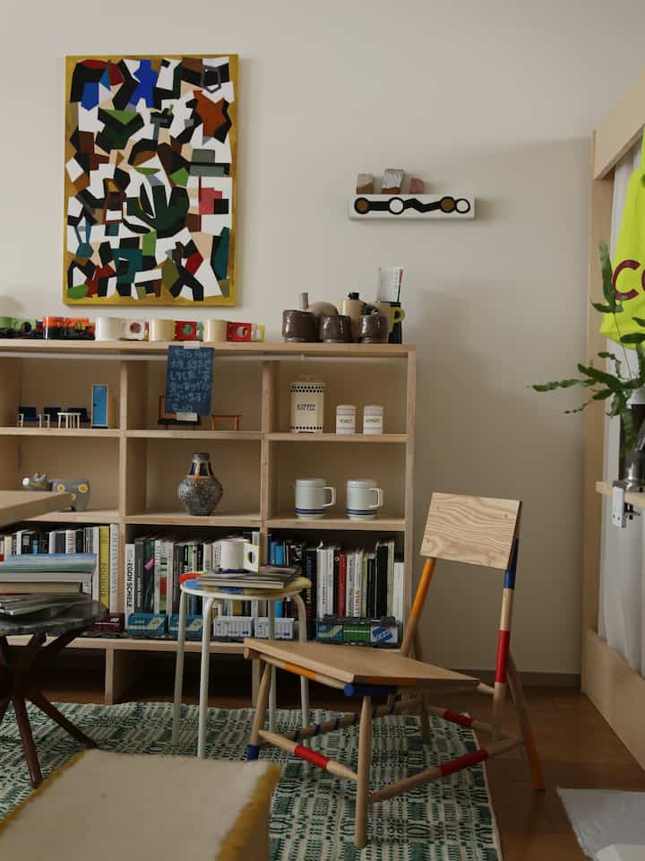Natural wood tones and green accents in a living room featuring a bookshelf, side table, and chair creating a cozy reading nook atmosphere