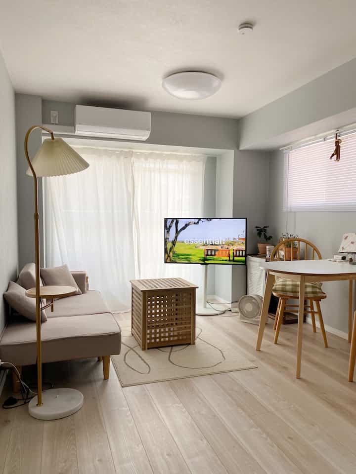 白いカーテンと木目調家具が配置された自然なモダンなリビングとダイニングの空間