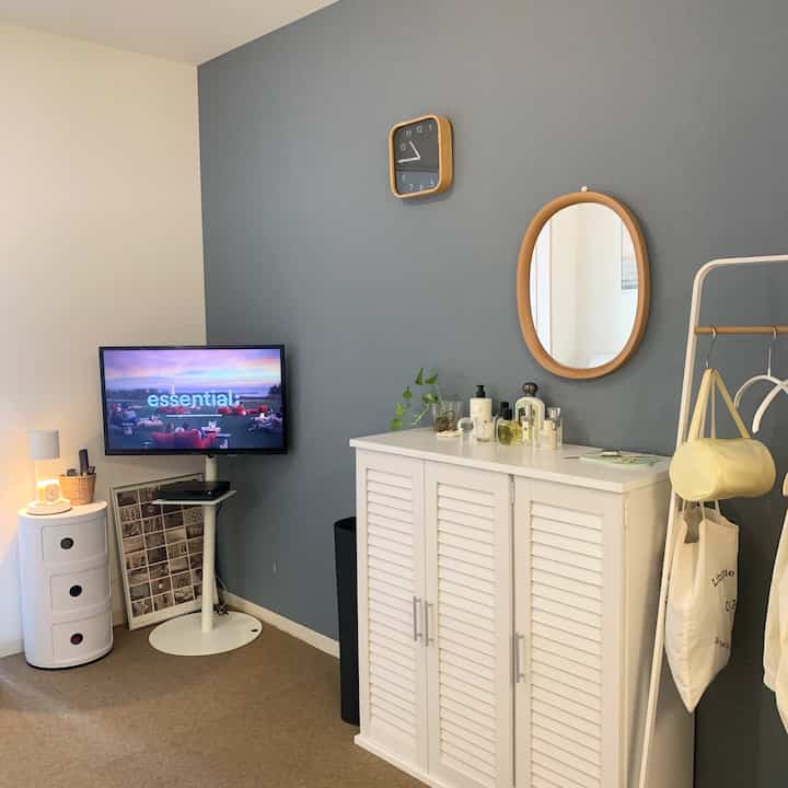 グレーの壁と白い家具が配置された、自然光が少ないシンプルなリビングルームのインテリア