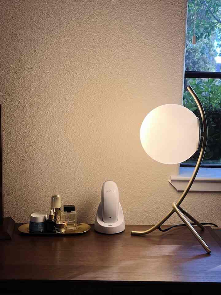 Natural brown-toned small vanity space featuring a table lamp and cosmetics with a cozy atmosphere